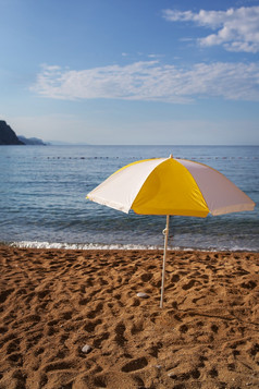 明亮的黄色的条纹海滩伞对的蓝色的天空海滩假期概念的地方为登记明亮的黄色的条纹海滩伞对的蓝色的天空海滩假期概念的地方为登记