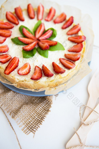 非常美丽的夏天芝士蛋糕装饰与草莓站白色木表格非常美丽的夏天芝士蛋糕装饰与草莓站白色木表格