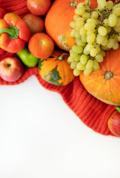 感恩节一天秋天收获梨苹果南瓜胡椒番茄白色背景和红色的布感恩节一天秋天收获梨苹果南瓜胡椒番茄白色背景和红色的布