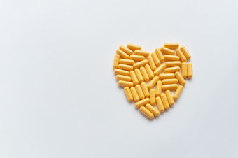 心形状的黄色的药片健康和心问题医学和医疗保健概念的地方为登记心形状的黄色的药片健康和心问题医学和医疗保健概念的地方为登记
