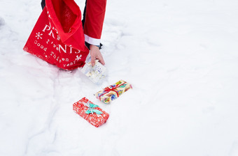 男人。穿着圣诞老人老人收集礼物雪森林的雪色彩斑斓的盒子与礼物男人。穿着圣诞老人老人收集礼物雪森林的雪色彩斑斓的盒子与礼物