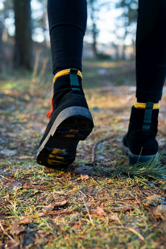 的女孩走通过的森林特写镜头鞋子对的背景的森林旅行徒步旅行和徒步旅行概念的女孩走通过的森林特写镜头鞋子对的背景的森林旅行徒步旅行和徒步旅行概念