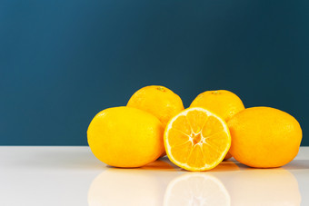 黄色的成熟的柠檬<strong>切</strong>片一<strong>半</strong>多汁的柑橘类<strong>水果</strong>的白色表格前面的蓝色的背景墙<strong>新鲜</strong>的<strong>水果</strong>