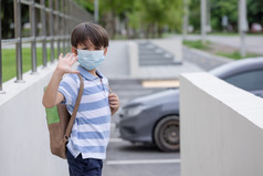 微笑可爱的小男孩与学校背包和保护脸面具准备好了为第一个一天学校在科维德流感大流行黑色的孩子会回来学校在冠状病毒流感大流行疾病