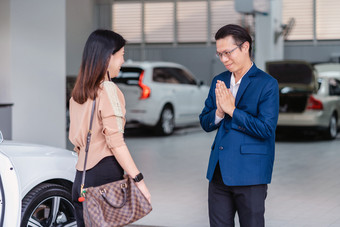 亚洲接待员欢迎的客户访问维护服务中心为检查的车展厅