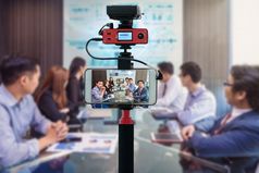特写镜头聪明的移动电话采取生活亚洲业务团队有视频会议相机为摄影师视频和生活流媒体概念