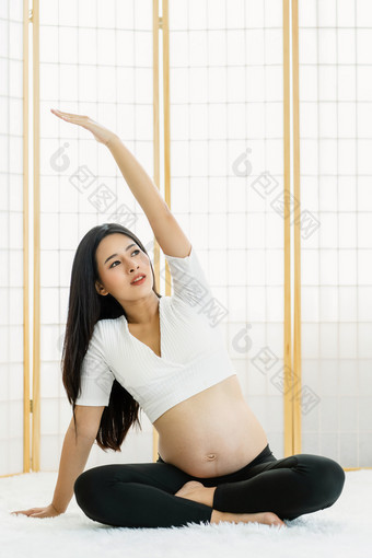 亚洲怀孕了做练习与瑜伽坐着和冥想日本风格房子的一点点地毯怀孕了锻炼概念准备母亲与好健康的