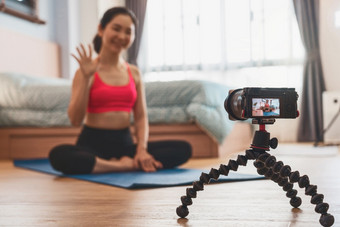 相机采取<strong>视频</strong>和生活亚洲女人练习瑜伽从首页卧室当科维德爆发<strong>健康</strong>的冥想锻炼冠状病毒流感大流行和检疫<strong>视频</strong>博客和影响者概念