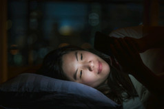 亚洲女人睡觉和使用聪明的移动电话为社会网络视频会议调用当科维德爆发检疫和冠状病毒流感大流行社会距离和新正常的概念