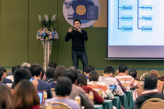 亚洲演讲者与休闲西装的阶段现在的屏幕的会议大厅研讨会会议业务和教育概念
