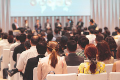 后视图观众的会议大厅研讨会会议哪一个有演讲者的阶段业务和教育关于投资概念