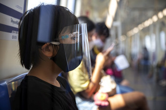 年轻的亚洲穿外科手术脸面具保护为传播疾病病毒新冠病毒冠状病毒爆发预防坐着地铁公共区域