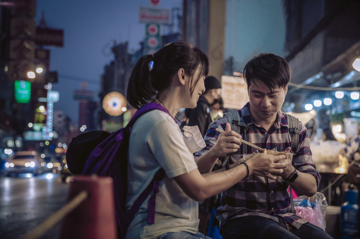 亚洲夫妇吃街食物晚上市场为旅游唐人街耀华力路曼谷