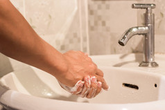 男人。洗他的手与肥皂在水槽的浴室概念卫生治疗