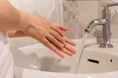 特写镜头年轻的女人洗手在水槽浴室首页卫生治疗概念