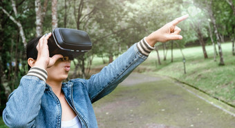 快乐女人穿虚拟现实<strong>头戴式</strong>耳机眼镜虚拟现实森林和享受的自然阳光明媚的夏天一天春天花园现代技术概念