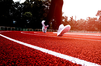运动女人体育运动衣服运行体育场跟踪女跑步者慢跑为锻炼锻炼健康的生活方式概念