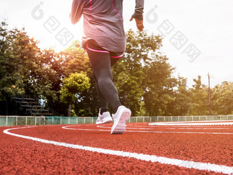 运动女人体育运动衣服运行体育场跟踪女跑步者慢跑为锻炼锻炼健康的生活方式概念