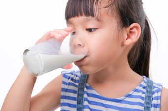 可爱的小女孩喝<strong>牛奶</strong>从玻璃孤立的白色背景小女孩享受喝<strong>牛奶</strong>之前会学校