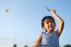 孩子玩与风筝而运行草地的湖日落健康的夏天活动为孩子们有趣的时间与家庭