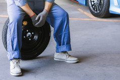 亚洲男人。车检查测量数量膨胀的橡胶轮胎车特写镜头手持有轮胎和蓝色的车为轮胎压力测量为汽车汽车车行业图像