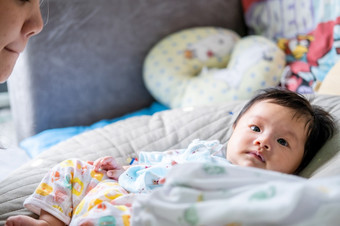 亚洲新生儿婴儿孩子眼睛联系与妈妈可爱孩子们与快乐家庭软床垫比喻生活生活健康的生活方式可爱的孩子婴儿产品健康产品为妈妈。和婴儿