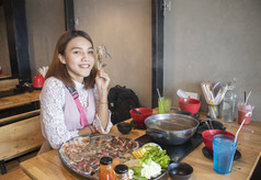 年轻的亚洲女人享受吃涮涮锅日本热能