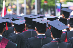 毕业生的大学毕业生持有帽子沿着与成功教育概念