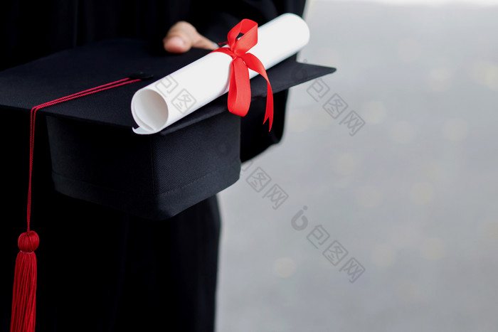 毕业关闭学生持有帽子和流苏红色的手在毕业典礼成功毕业生的大学概念教育祝贺毕业仪式