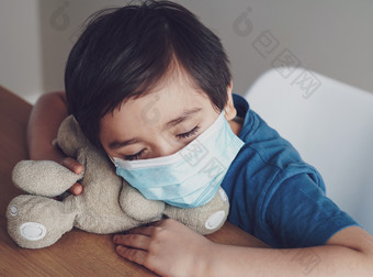 男孩累了从胸部咳嗽穿医疗脸<strong>面具</strong>为保护孩子下降睡眠而玩与玩具孩子保持首页为保护冠状病毒流感爆发和疾病保护