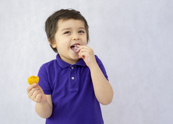 肖像快乐孩子吃<strong>蛋白</strong>杏仁饼干白色背景微笑孩子享受他的甜蜜的零食小男孩持有食物和看相机与微笑脸积极的童年概念