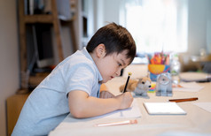 学校孩子使用颜色笔画和绘画白色纸表男孩做在线首页工作使用平板电脑孩子着色狗玩具纸电子学习在线教育