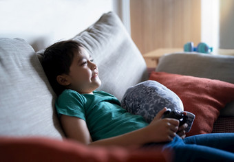 肖像快乐孩子持有视频游戏控制孩子玩在线游戏首页年轻的男孩选址沙发有有趣的玩与玩具和放松的周末<strong>新生活</strong>方式后科维德