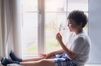 快乐孩子吃一些冰奶油肖像英俊的年轻的男孩坐着下一个窗口有点心孩子与微笑脸放松首页孩子看相机