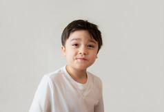 肖像可爱的快乐年轻的男孩穿白色衬衫看与惊讶脸头拍摄积极的孩子与微笑脸和使有趣的脸孩子们天概念
