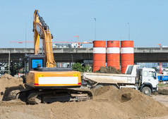 大挖掘机加载的沙子和土壤的卡车为建设的火车站的城市区域泰国