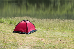红色的帐篷附近的小储层与的反射从的水表面的国家公园