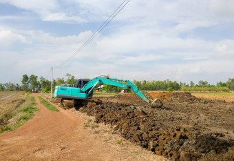 的现代挖掘机工作土方工程为挖掘的<strong>池塘</strong>附近的帕迪场存储的水为使用农业的夏天前面视图为的复制空间