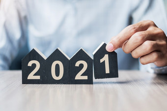 年轻的商人手持有快乐新一年与房子模型表格办公室新房子金融财产保险真正的房地产储蓄和新一年决议概念