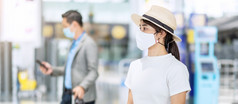 年轻的女穿脸面具与行李检查飞行时间机场保护冠状病毒疾病感染亚洲女人旅行者准备好了旅行新正常的和旅行下新冠病毒