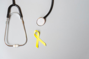 童年癌症肉瘤骨膀胱和自杀预防意识月黄金黄色的丝带为支持人生活和疾病孩子们医疗保健和世界癌症一天概念