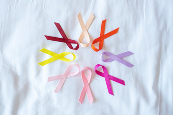 世界癌症一天2月色彩斑斓的意识丝带红色的橙色紫色的粉红色的桃子和黄色的颜色为支持人生活和疾病医疗保健和医疗概念