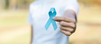 11月前列腺癌癌症意识月女人持有蓝色的丝带为支持人生活和疾病医疗保健国际但父亲世界癌症一天和世界糖尿病一天概念