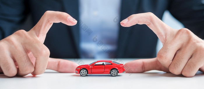 商人手封面保护红色的车玩具表格车保险保修修复金融银行和钱概念