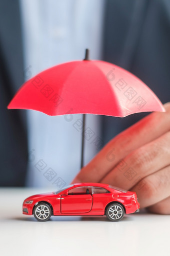 商人手持有伞和<strong>封面</strong>红色的车玩具表格车保险保修修复金融<strong>银行</strong>和钱概念