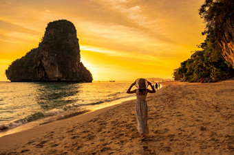 女人<strong>旅游</strong>白色衣服和他走phra什么时候洞穴海滩日落莱利甲米<strong>泰国</strong>假期旅行夏天<strong>旅游</strong>热和假期概念