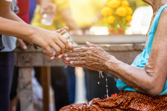 倒水的手受人尊敬的长老和问为祝福快乐为的泼水节节日泰国传统的泰国新一年