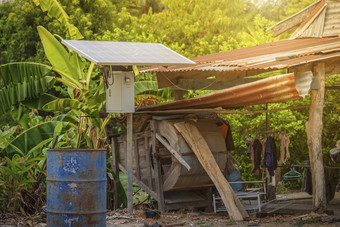 太阳能面板<strong>农村房子</strong>区域和老石油桶是准备好了回收工业农用工业家庭农村风格泰国替代能源概念
