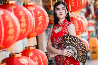 亚洲女人穿红色的传统的<strong>中国</strong>人旗袍装饰与纸灯笼与的<strong>中国</strong>人字母祝福写《财富》杂志祝福赞美装饰为<strong>中国</strong>人新一年