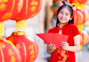 亚洲女孩穿红色的传统的中国人旗袍装饰持有红色的信封手和灯笼与的中国人文本祝福写《财富》杂志祝福为中国人新一年